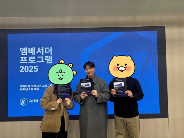 아비트럼 앰배서더 프로그램 2025 안내 화면 앞에서 참가자 세 명이 인쇄물을 들고 선 사진